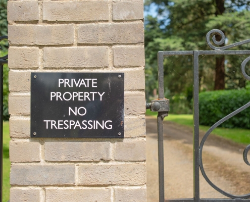 Sign on gate wall stating 'Private Property, No Trespassing'
